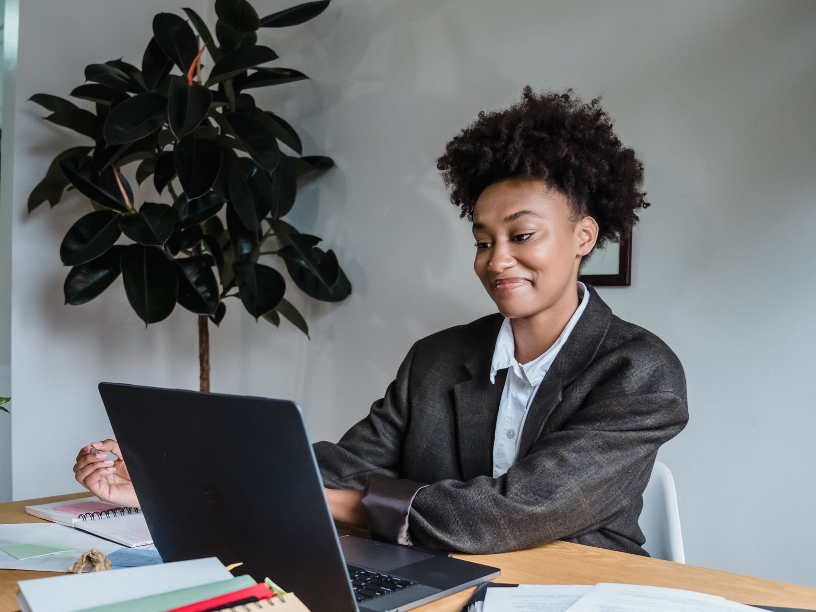 A smiling woman entrepreneur working at her desk in a modern office